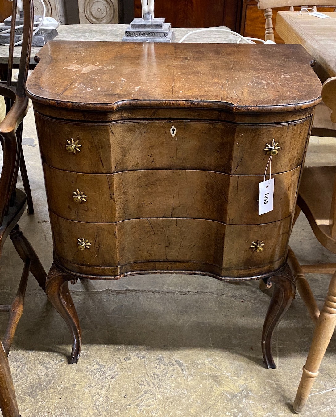 A 1930's walnut serpentine chest of three drawers on cabriole legs, width 64cm, height 77cm